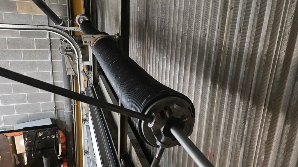 A technician from Garage Door Service Illinois is adjusting a garage door spring.
